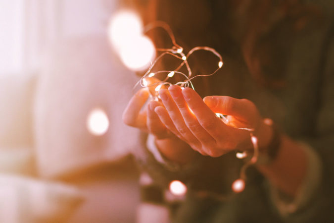 Image décorative : mains tenant une guirlande de lumères